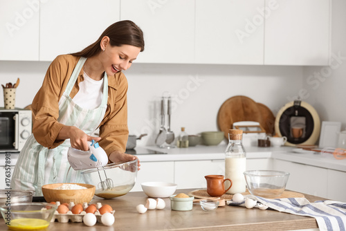 Young woman whipping eggs w...