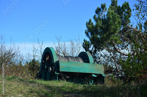 a giant reel of television cable and a winch on the ground