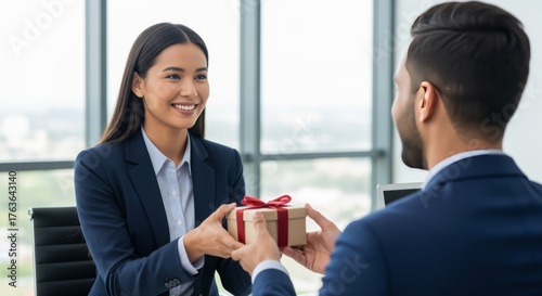 Smiling Businesswoman Receiving Gift Box in Modern Office Setting