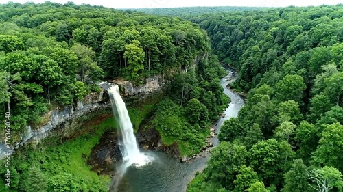 Aerial view of a stunning waterfall cascading into a river surrounded by lush green forest