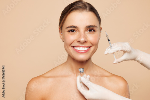 Schilderij op canvas Beautiful fun half naked topless young woman 20s with nude make up getting fillers injection isolated on plain beige color background studio portrait
