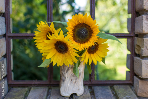 Sunflowers (helianthus) in a vase in old window