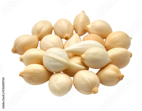 A pile of peeled, ivory-colored cloves against a stark, black background