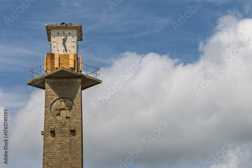 Clock tower of remarkable building of Rail museum of Dinan in front of blue clouded sky in Cotes-d'Armor, Brittany, France