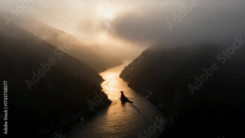 Dramatic Golden Hour Sunset Over a Misty Mountain River Valley with a Lone Figure in a Kayak
