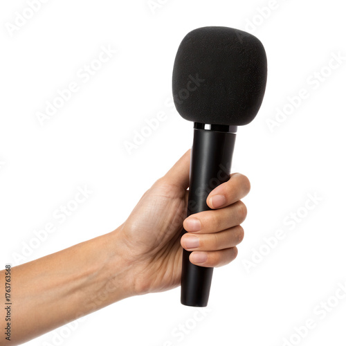 A hand holds a microphone with a fuzzy windscreen against a black background, emphasizing the equipment for audio recording or broadcasting.