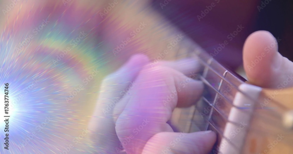 Fototapeta premium Pressing musician's left hand forming chord on acoustic guitar strings in studio with rainbow flare