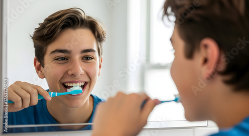Teen Brushing Teeth Smiling in Mirror