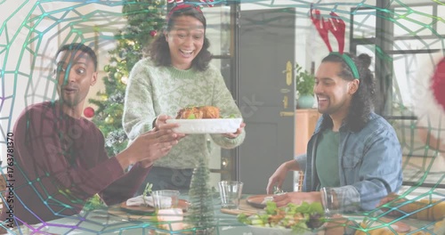 Host carrying roast toward table, guests passing salad and rolls, sharing holiday hospitality