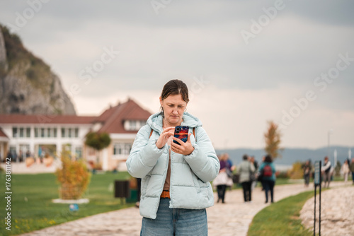 Woman looking at her phone during an outdoor walk.