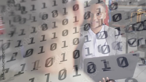 Camera focusing factory presenter pointing toward binary code explaining results typing laptop