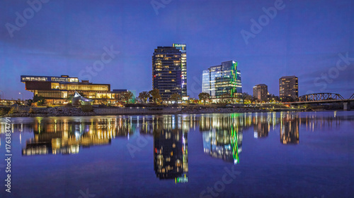 Bild auf Leinwand Wide angle nightscape, cityscape of Saskatoon River Landing area with beautiful water reflections