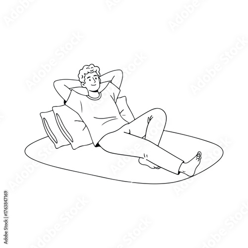 A relaxed young man lying on a soft mat with pillows