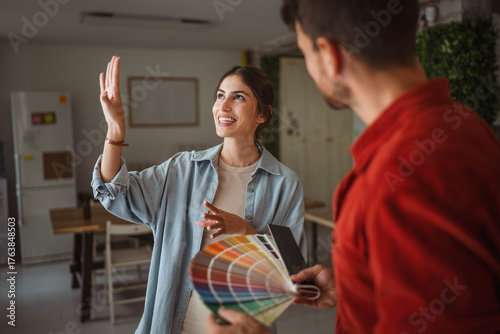 Canvas Print Woman choosing paint color with interior designer holding color palette