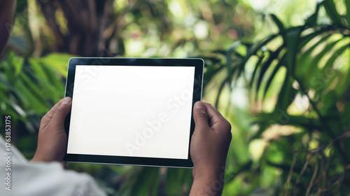 Mockup de imagem de homem segurando um tablet com tela em branco na natureza.
