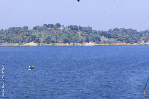 Green Hills and Sparkling Lake under Blue Sky