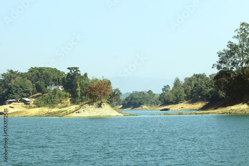 Green Hills and Sparkling Lake under Blue Sky