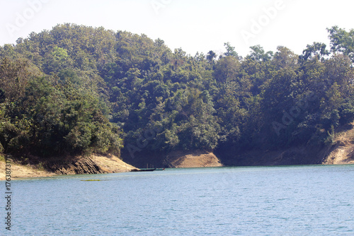 Green Hills and Sparkling Lake under Blue Sky