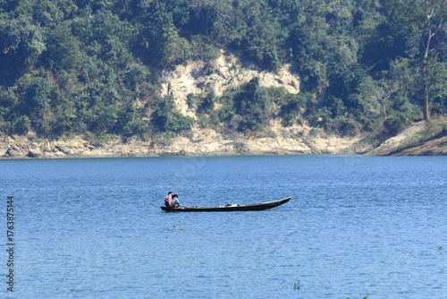 Fisherman on Wooden Boat in Calm River