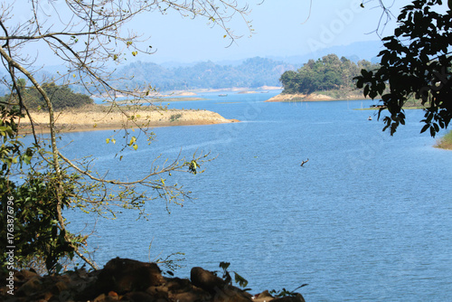 Green Hills and Sparkling Lake under Blue Sky