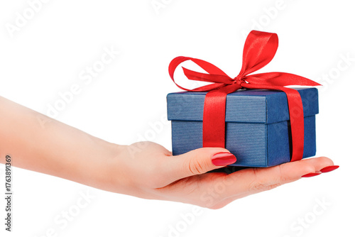 Female hand holding small blue gift box with red satin ribbon bow isolated elegant holiday concept for birthday, Christmas, Valentines Day, or romantic celebration design.