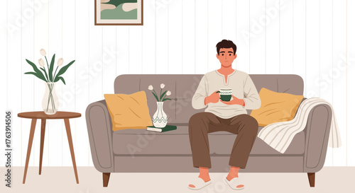 Young man relaxing on sofa with a cup of tea in a serene interior setting