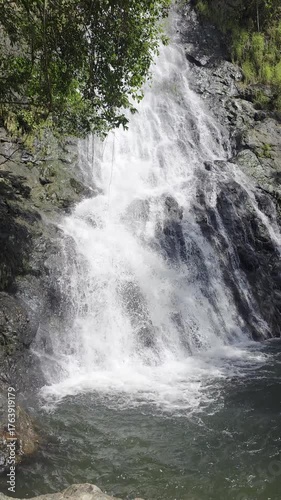 Majestic Waterfall Cascading Into Serene Pool Surrounded By Lush Greenery And Smooth Rocks