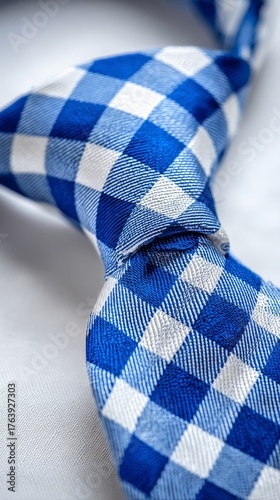 Stylish Blue and White Checkered Tie Resting on a Table With Soft Fabric Back...