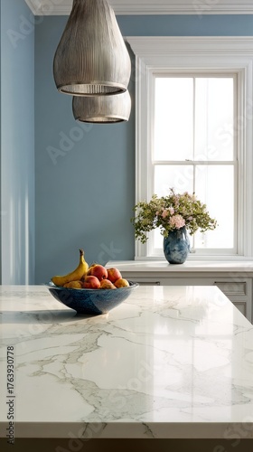 Modern Kitchen With Marble Countertop, Fruit Bowl, and Fresh Flowers in a Bri...