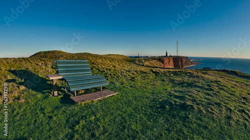 Photos View of a bench installed in green gardens facing the sea to admire the sunset