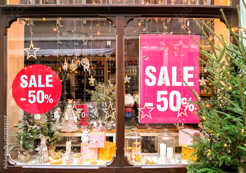 Christmas store window display with festive decorations and a red SALE -50% banner.