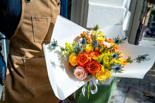 Florist holding vibrant flower bouquet preparing for delivery
