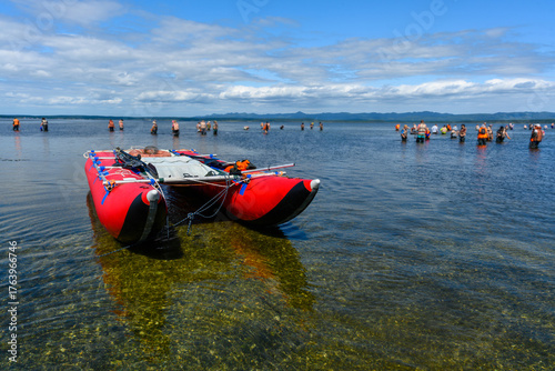 Bright day for fun at the shallow waters near the beach with a group of people enjoying the sun