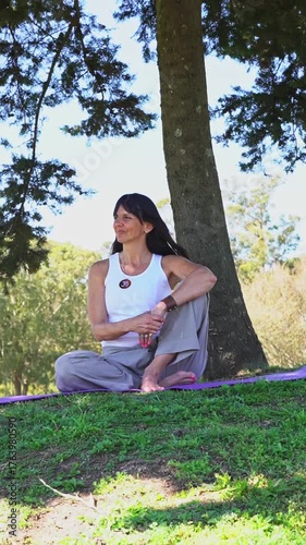 Smiling woman sitting under a tree for a mindful moment of reflection and peace