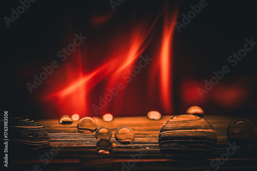 Water droplets shimmer against blazing flames creating a contrast of cool and heat in a dark setting