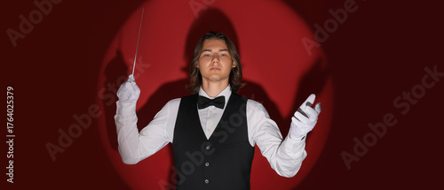 Male conductor on red backg...