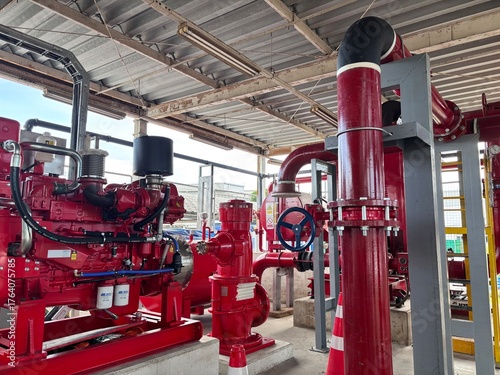 Powerful industrial diesel fire pump system with bold red engine, pipes, and control valves, ready for emergency fire suppression. This safety infrastructure ensures fire protection for factories 