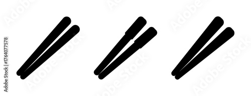 Three pairs of black bamboo chopsticks arranged diagonally on a white surface
