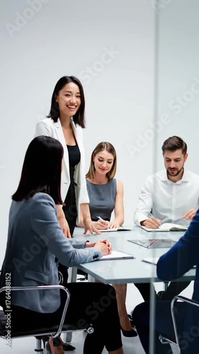 A diverse group of business professionals in formal attire engaged in a meeting around a table