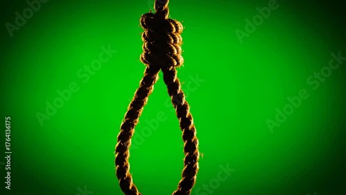 Dark Hanging Rope Against a Bright Green Background Close-Up