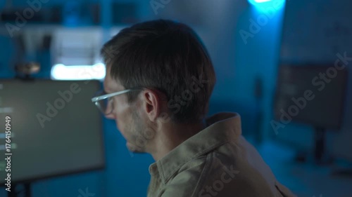 Cybersecurity engineer working late at computer in dark office