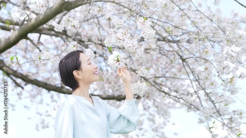 桜の花びらを見る若い女性　ライフスタイルイメージ