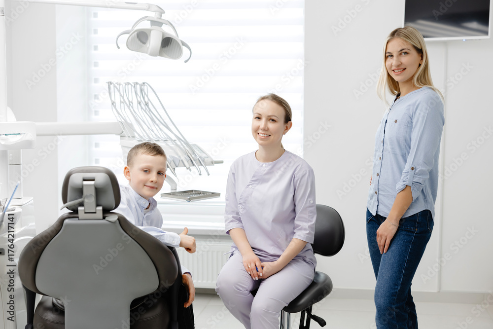 Obraz premium Dentist explaining dental hygiene to mother and child in clinic