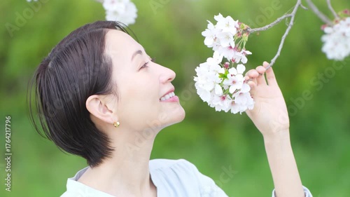 桜の花びらを見る若い女性　ライフスタイルイメージ