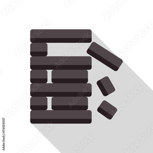Wooden block tower game falling with some blocks on the ground and long shadow