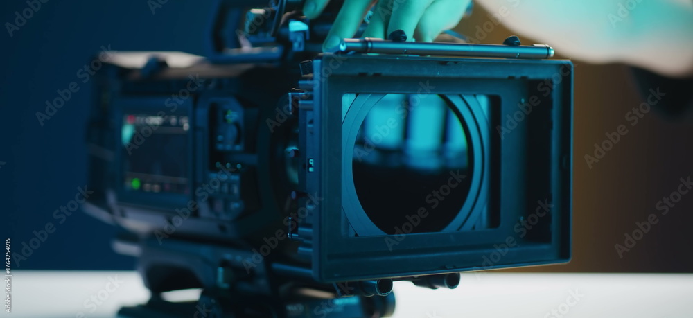 Fototapeta premium A person adjusts a professional video cameras lens for optimal.