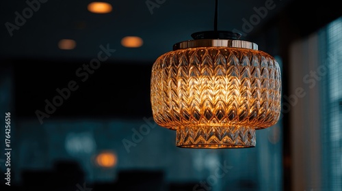 Ornate amber pendant lamp in a dimly lit room.