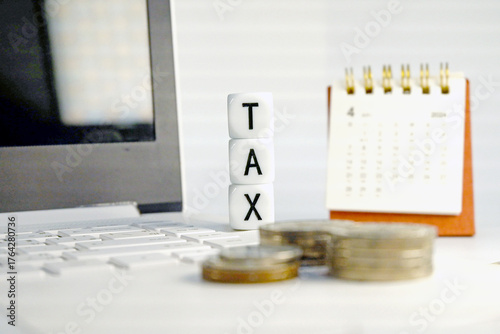 Tax Season: tax time reminder background digitally generated image stock photo copy space white dice vertically stack on the computer with coins stacks foreground and calendar background