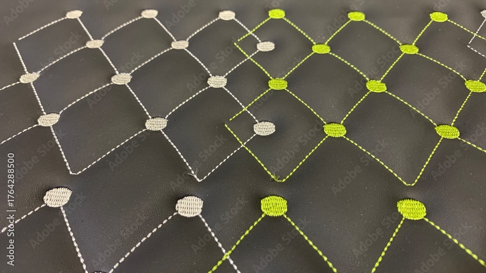 Obraz premium Modern quilted pattern with lime green and silver stitching on rich black fabric creates trendy luxury