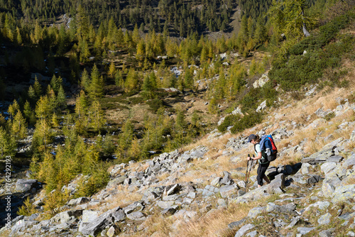 A woman hiking in the Ticino mountains, Switzerland, on a beautiful, autumn day.